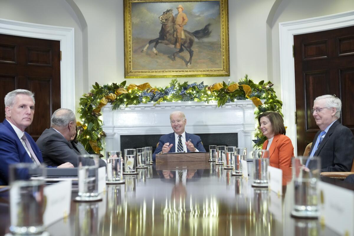 Four men and one woman sit around a large table.