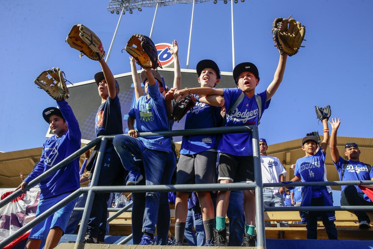 Young Dodgers fans look for a ball before Game 1 of the National League Division Series between the Dodgers and Washington Nationals in October.