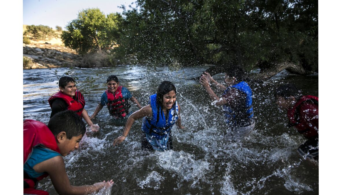 From left: Ramiro Rellano, 8; Alexander Quiroz, 10; Steve Arzate, 11; Xiomara Arellano, 10; Enrique Quiroz, 11; and Randy Arzate, 9, play in the water at Keyesville Camp.