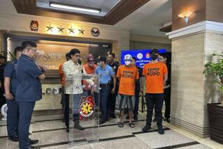 El secretario de Interior de Filipinas, Benhur Abalos, ofrece una conferencian de prensa en Manila, Filipinas, el 5 de junio de 2024, junto a cuatro policías (vestidos de naranja) acusados de secuestrar a cuatro turistas para pedir un rescate. (AP Foto)