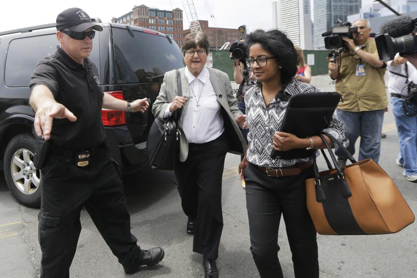 A member of the Boston Police Bomb Squad points the way for death penalty opponent Sister Helen Prejean, middle, as she departs federal court in Boston after testifying during the penalty phase in Dzhokhar Tsarnaev's trial Monday, May 11, 2015.