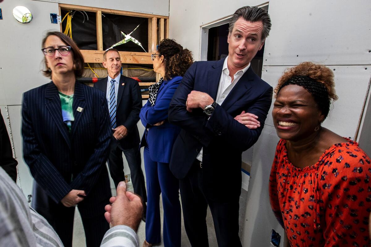 Gov. Gavin Newsom chats with Felicia Smith, right, at her home, where he signed a package of bills on housing in 2019.