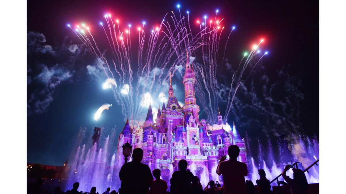 Visitors watch fireworks explode over the castle at an event to mark the first anniversary of the opening of Shanghai Disneyland.