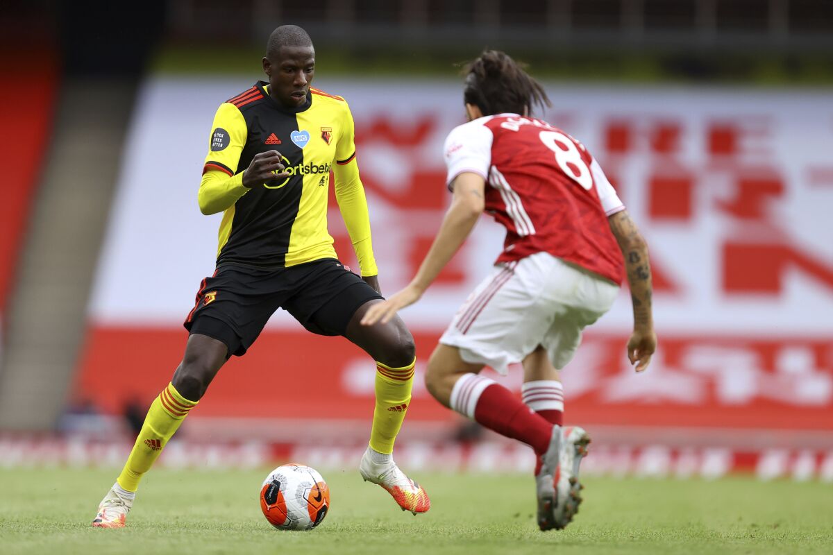 Watford's Abdoulaye Doucoure, left, drives against Arsenal's Dani Ceballos during the second half of the English Premier League soccer match between Arsenal and Watford at Emirates Stadium in London, England, Sunday, July 26, 2020. (AP photo/Julian Finney, Pool)