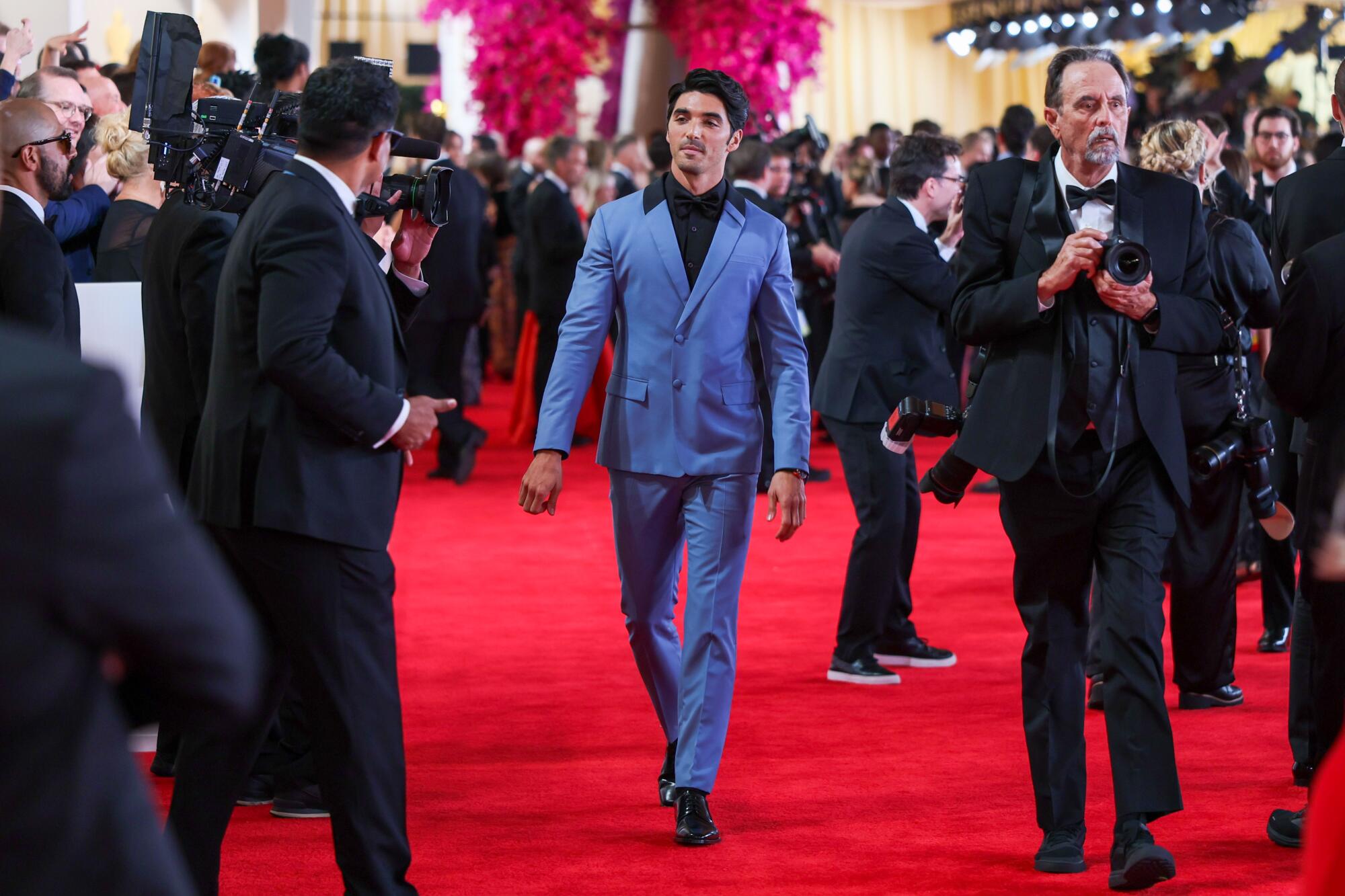 Taylor Zakhar Perez wears a blue suit as he walks the red carpet. 