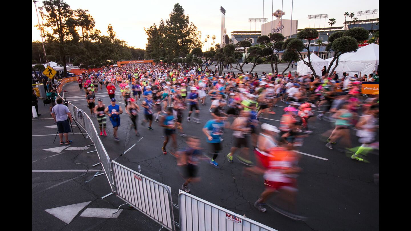 Runners begin the first mile as the sun rises at the start of the 30th Los Angeles Marathon.