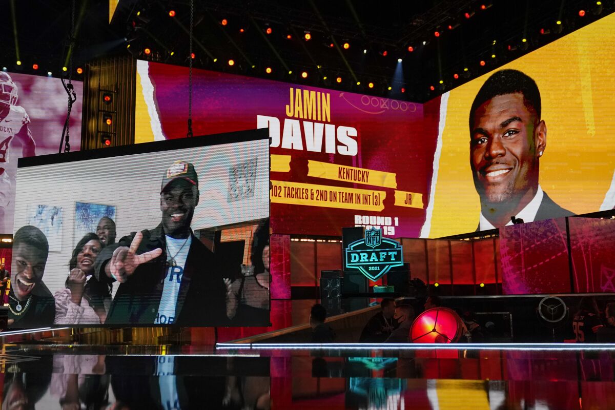 Images of Kentucky linebacker Jamin Davis are shown on stage after he was chosen by the Washington Football Team with the 19th pick in the first round of the NFL football draft Thursday April 29, 2021, in Cleveland. (AP Photo/Tony Dejak)