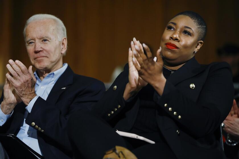 FILE - In this Jan. 27, 2020, file photo, Democratic presidential candidate, former Vice President Joe Biden and senior adviser Symone Sanders participate in a campaign event in Iowa City, Iowa. Biden's status as Democratic presidential nominee-in-waiting means the party will choose another man for an office never held by a woman. But he's running with plenty of women behind him, including a yet-to-be-named vice presidential running mate. (AP Photo/Matt Rourke, File)