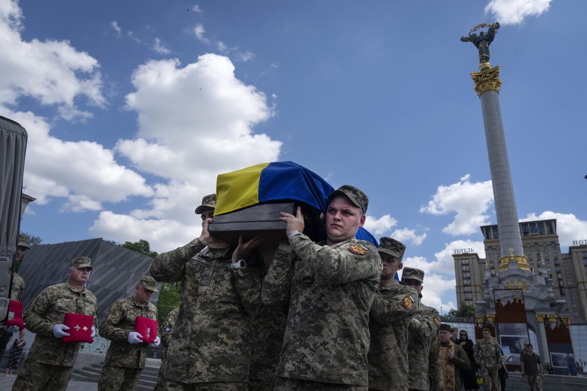 Soldiers carry a coffin covered with the Ukrainian flag during a funeral ceremony in Kyiv's main square.