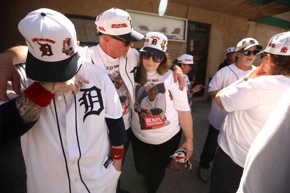 Mourners dressed in baseball jerseys, T-shirts and ball caps. 