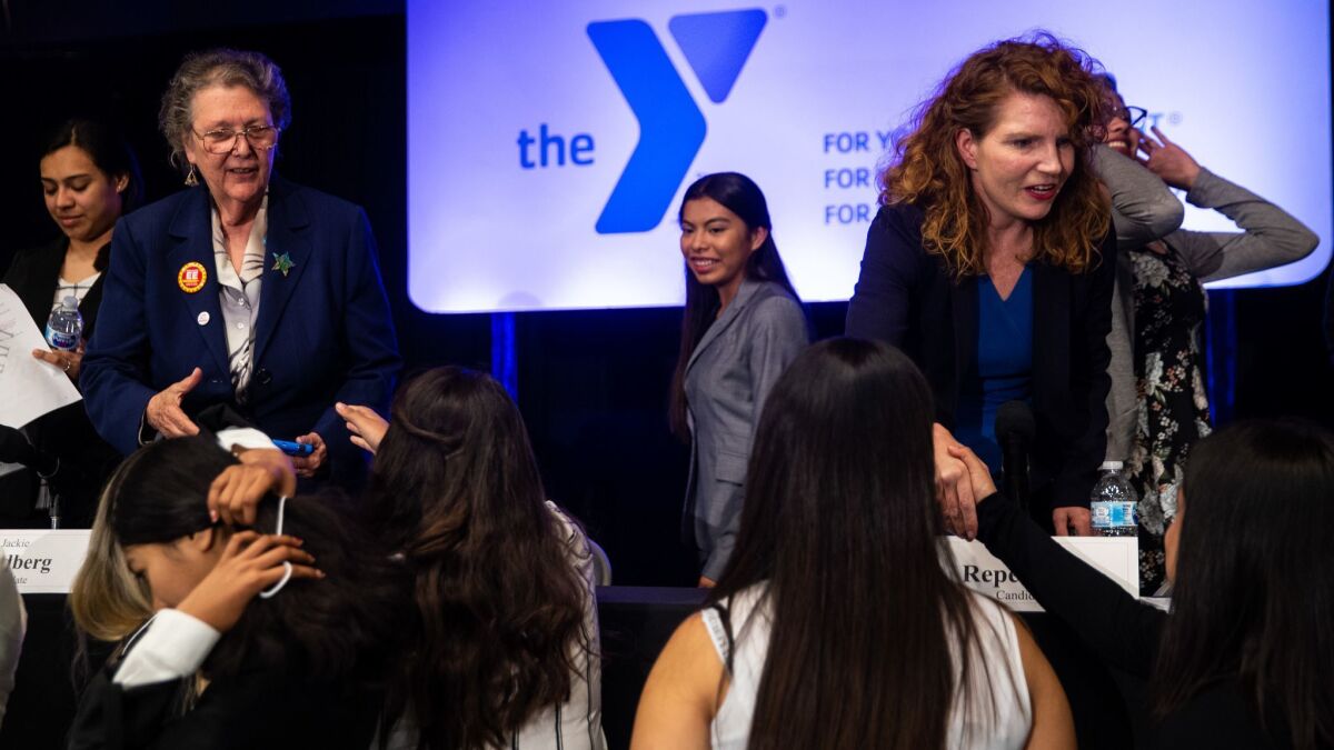 Students shake hands with L.A. Board of Education candidates Jackie Goldberg, left, and Heather Repenning, right, at the Southeast Rio Vista YMCA at Maywood Center on April 11 in Maywood.