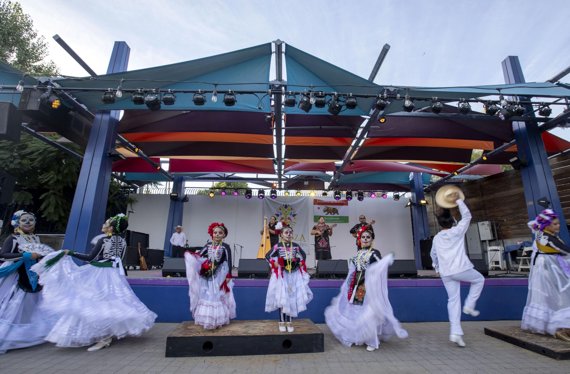 Grupo Folklórico Huitzillin dances in front of the stage while Tenocelomeh plays onstage.