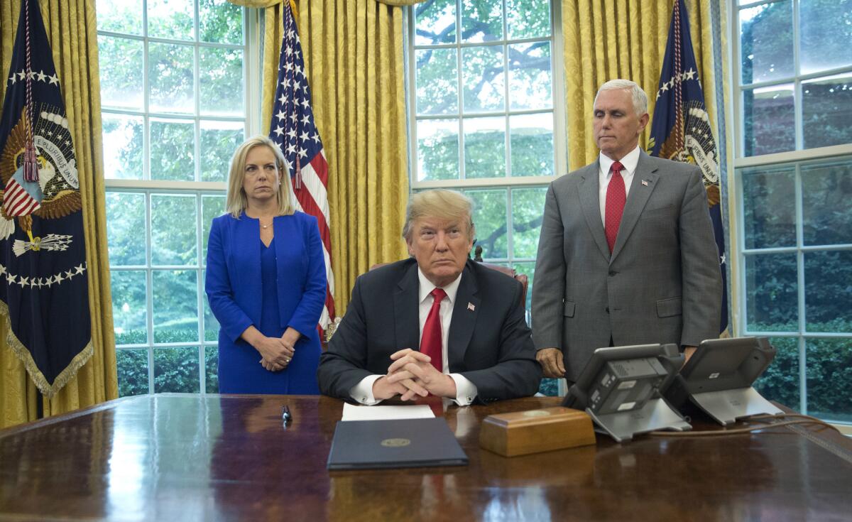President Trumps sits in the White House with Homeland Security Secretary Kirstjen Nielsen and Vice President Mike Pence.