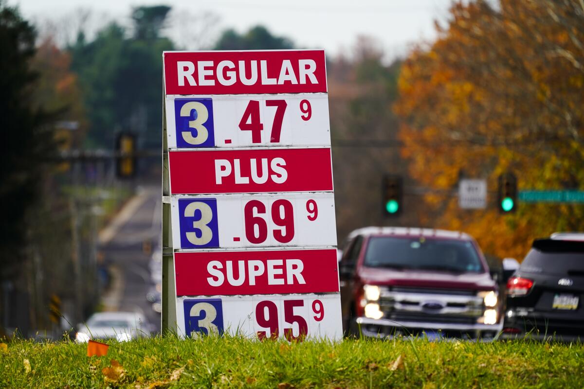 Gasoline prices are displayed at a station, with $3.47 for a gallon of regular.