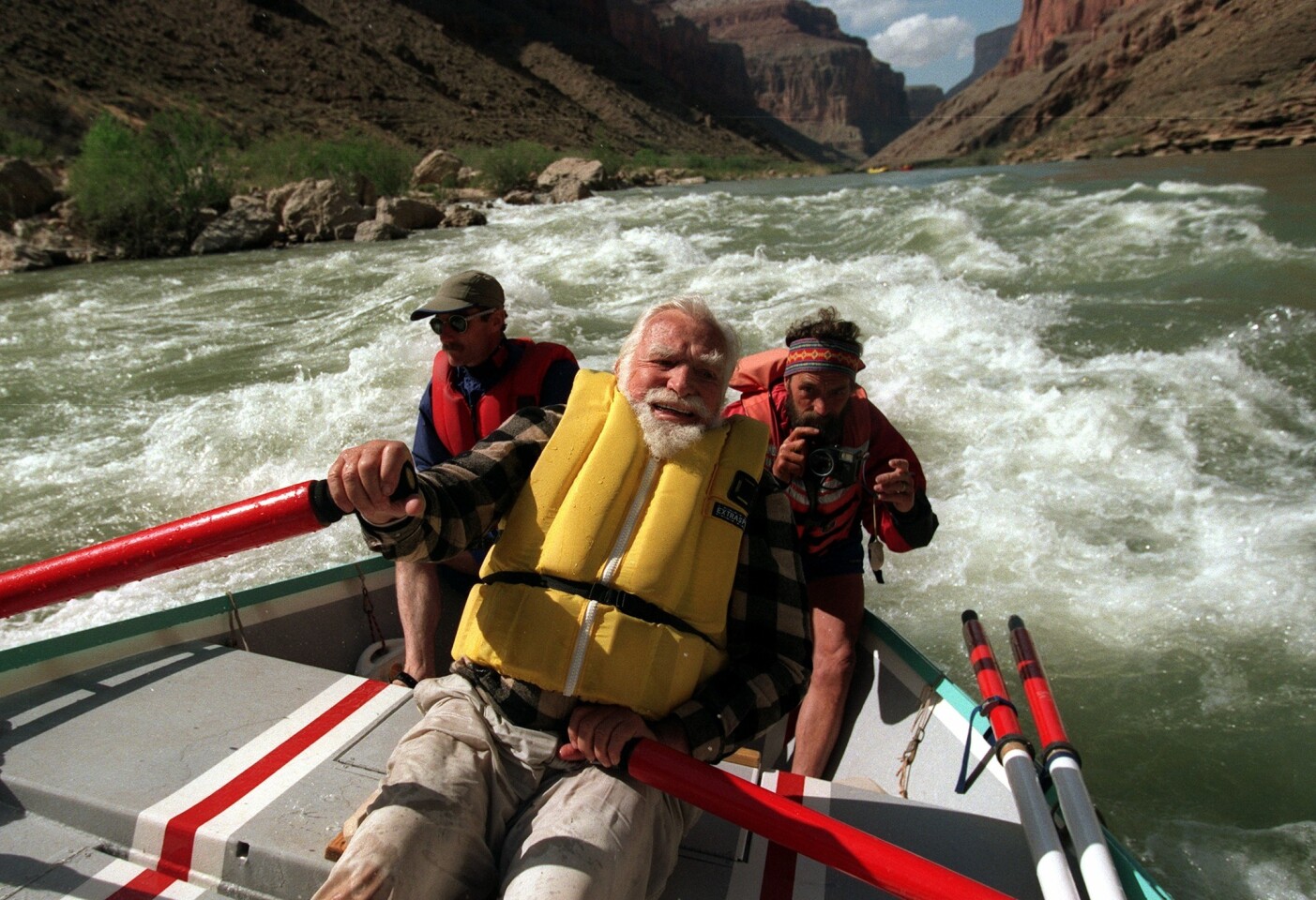 Wilderness advocate Martin Litton, center, a legendary Colorado River guide, navigates the river's 60 Mile Rapid with Lew Steiger, left, and Michael Powers in 1997. Litton died Nov. 30, 2014, at the age of 97.
