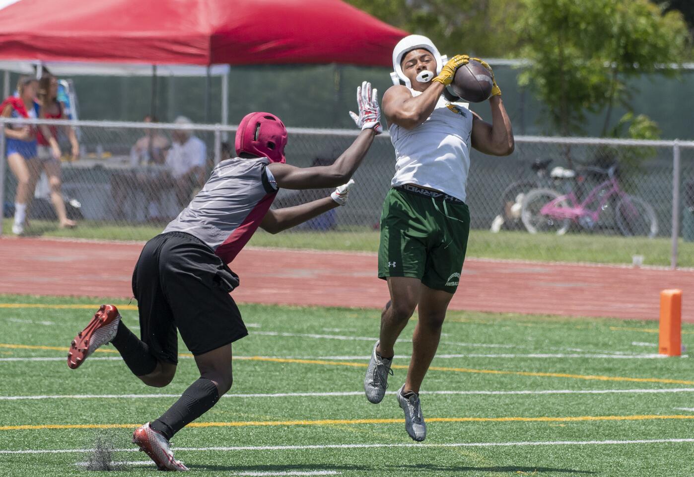 Edison's Isaiah Palmer goes up to catch a pass against a Downey defender during the Battle at the Beach seven-on-seven football passing tournament on Saturday, July 7.