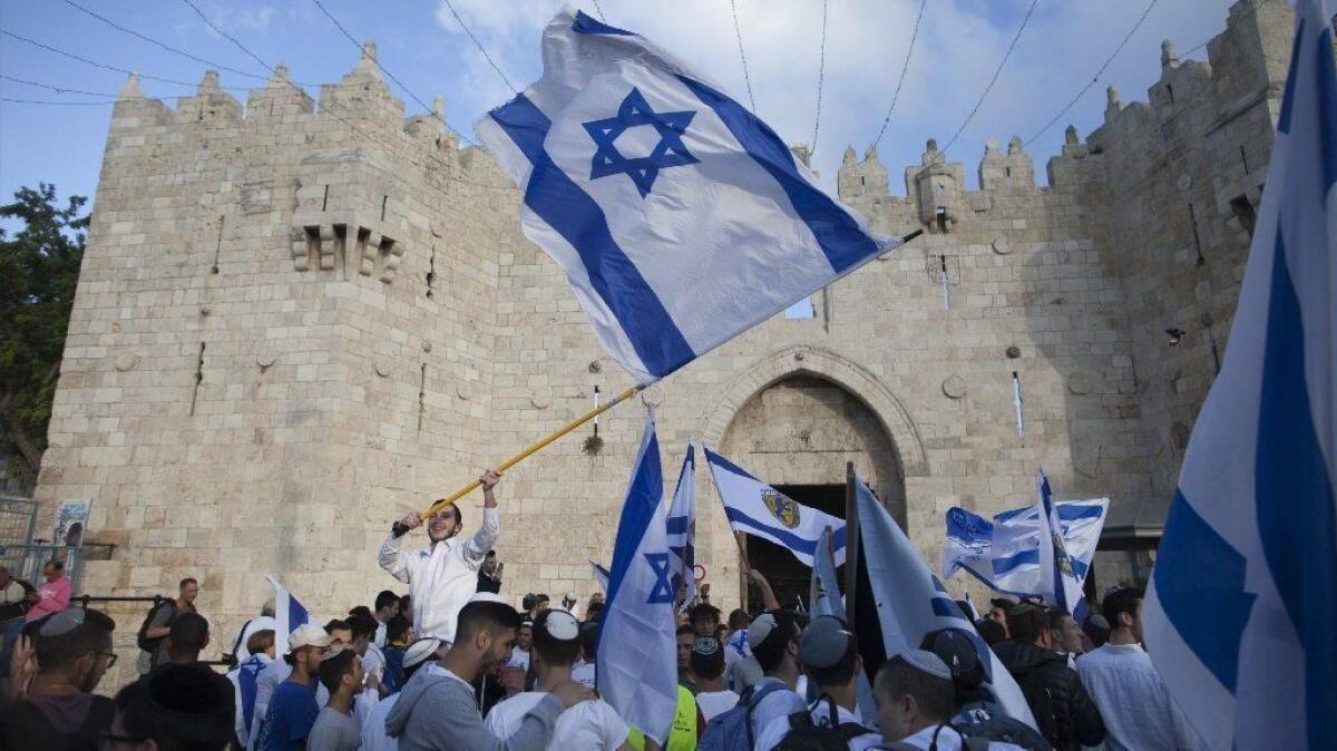 Israelis wave their national flag during a march in Jerusalem on May 13, 2018.