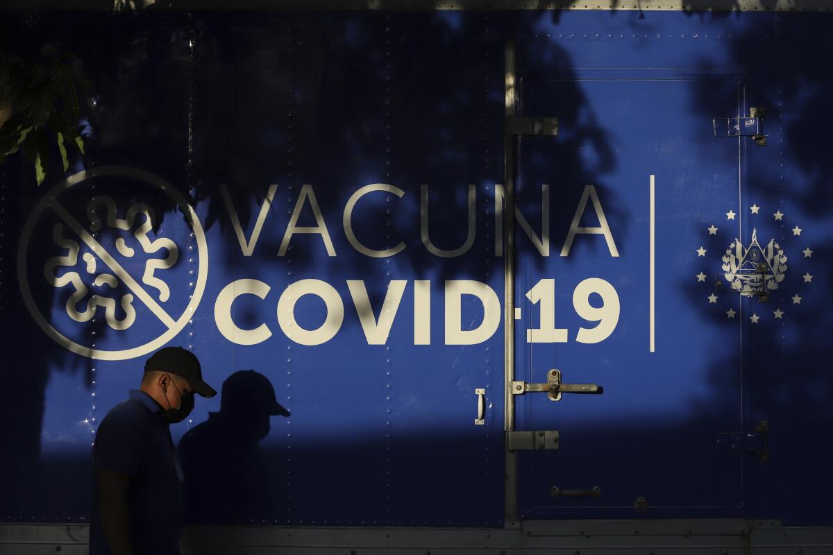 Un conductor pasa junto a un camión refrigerado del Ministerio de Salud que transporta dosis de vacunas para el COVID-19 
