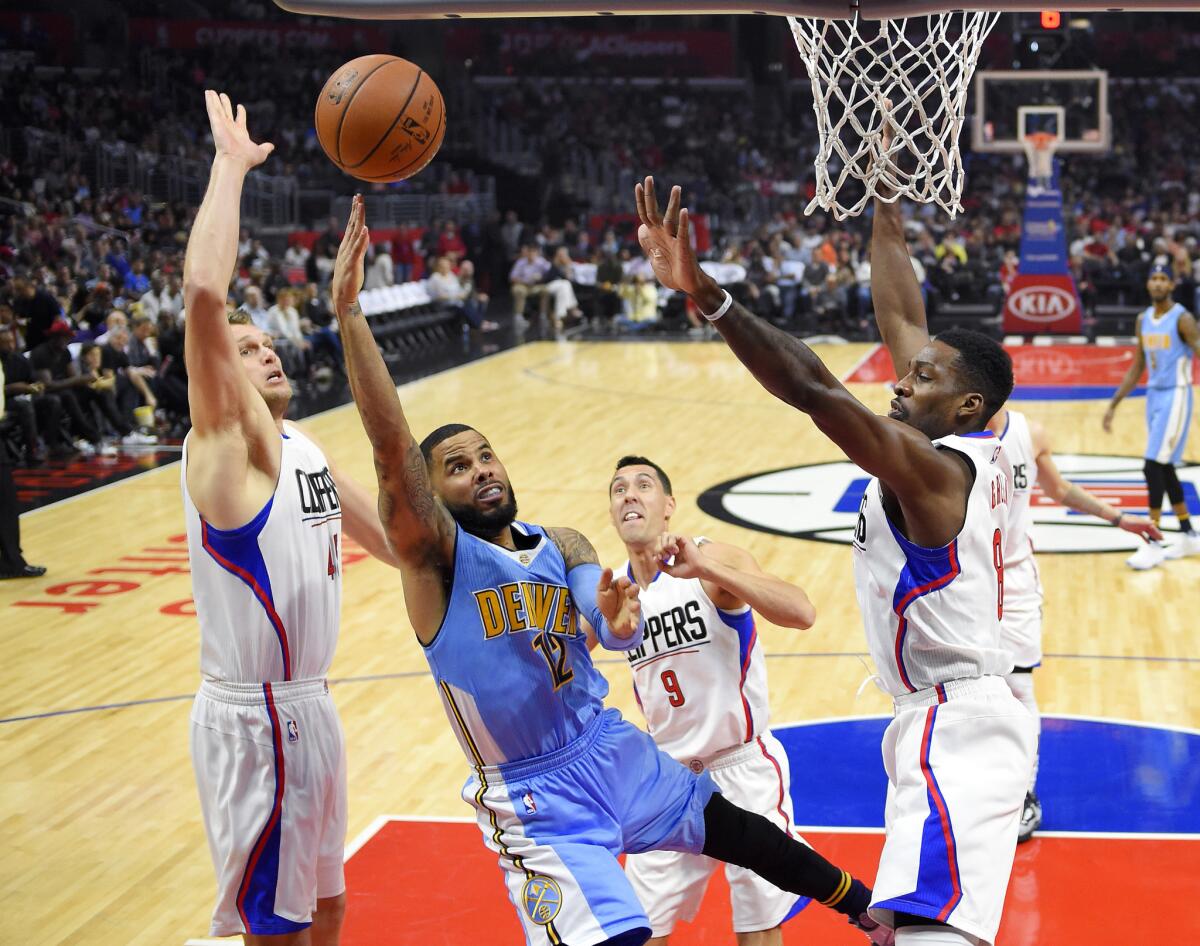 Denver Nuggets guard D.J. Augustin shoots against the Clippers' Cole Aldrich, left, Pablo Prigioni and Jeff Green on Sunday.