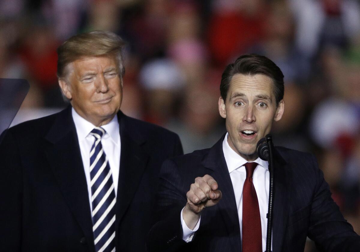 FILE - President Donald Trump listens as Republican Senate candidate Josh Hawley speaks during a campaign rally at Columbia Regional Airport, Thursday, Nov. 1, 2018, in Columbia, Mo. A federal lawsuit accuses the National Rifle Association of violating campaign finance laws by using shell companies to illegally funnel up to $35 million to Republican candidates, including former President Trump, Sen. Hawley of Missouri and others. The Campaign Legal Center filed the lawsuit Tuesday, Nov. 2, 2021, in Washington on behalf of Giffords, a gun control nonprofit founded by former Democratic U.S. Rep. Gabby Giffords. (AP Photo/Charlie Riedel, File)