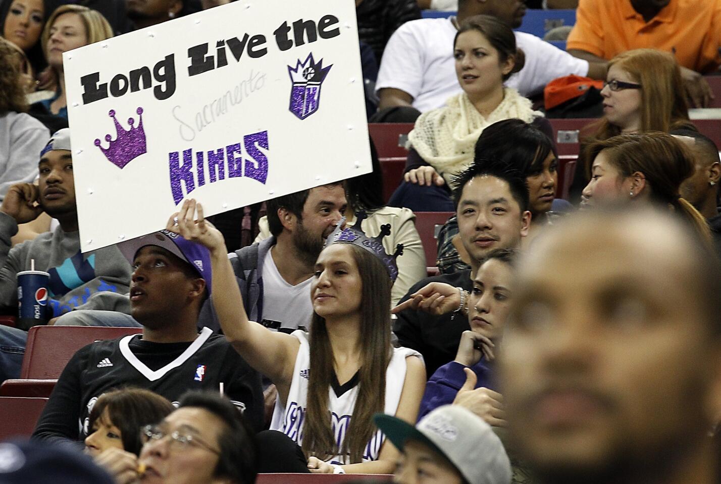 A fan holds up a sign that pleads with the Sacramento Kings to stay put rather than moving out of town.