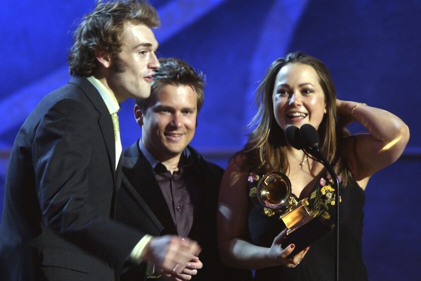 Nickel Creek members from left, Chris Thile, Sean Watkins, and Sara Watkins, accept the award for best contemporary folk album during the pre-telecast of the 45th Annual Grammy Awards in New York, Sunday, Feb. 23, 2003. (AP Photo/Mark Lennihan)