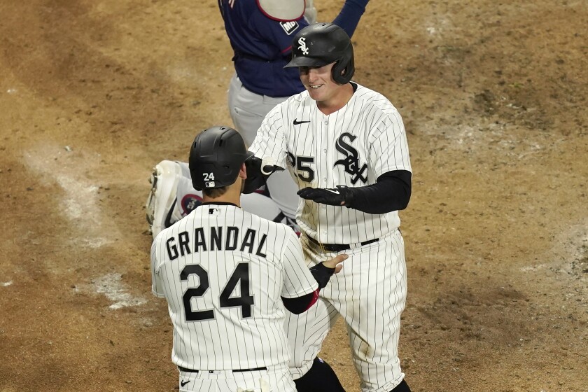 Chicago White Sox's Andrew Vaughn (25) celebrates his home run off Minnesota Twins starting pitcher J.A. Happ with Yasmani Grandal during the fourth inning of a baseball game Wednesday, May 12, 2021, in Chicago. (AP Photo/Charles Rex Arbogast)