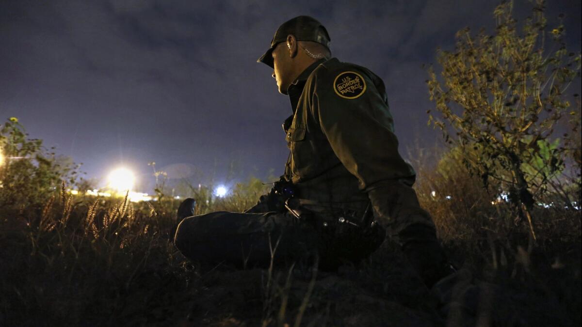 Border Patrol Agent Robert Trevino stays low as he keeps watch in Roma, a city in the Rio Grande Valley in southern Texas.