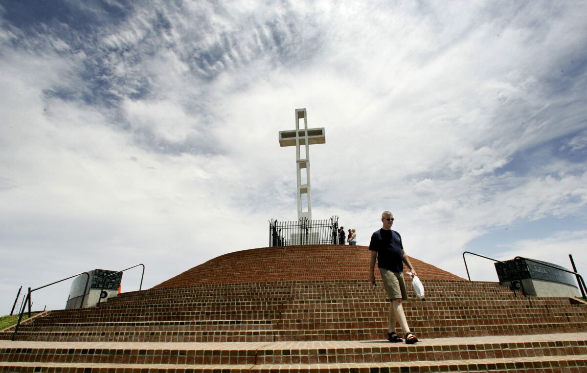 A man walks down some steps after collecting funds from the donation box at the Mt. Soledad war memorial in San Diego.