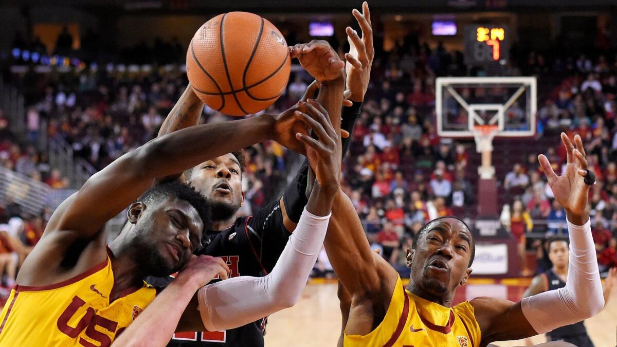 USC forward Chimezie Metu and guard Shaqquan Aaron, right, reach for a rebound along with Utah forward Chris Seeley in the second half.