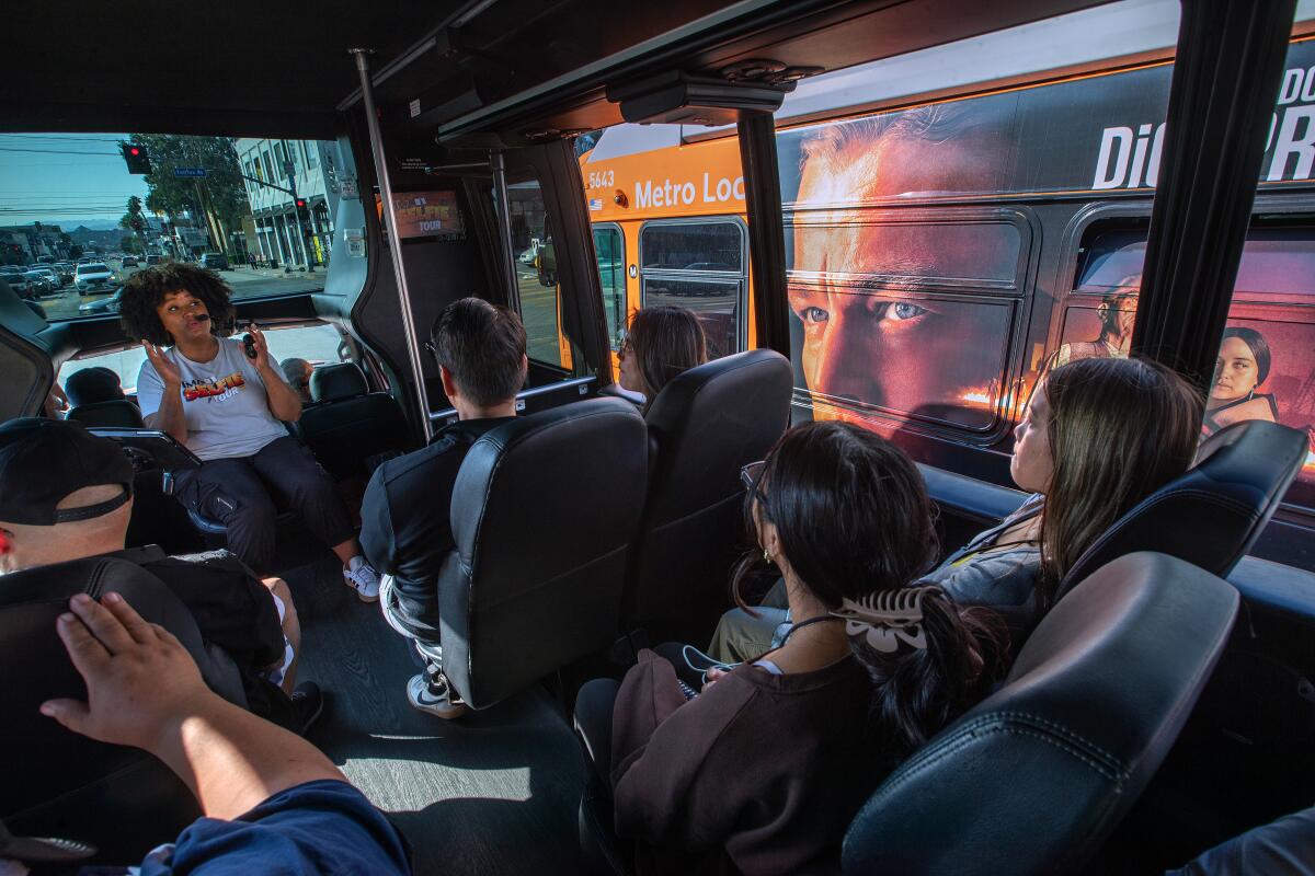 Five people sitting on a tour bus, one faces the other four