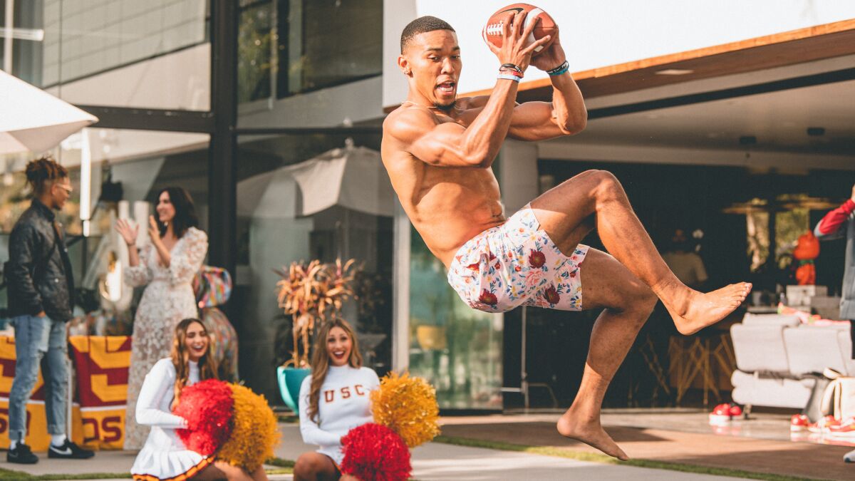 USC receiver Amon-ra St. Brown jumps into a pool at an event showing off the university's in-house creative lab.