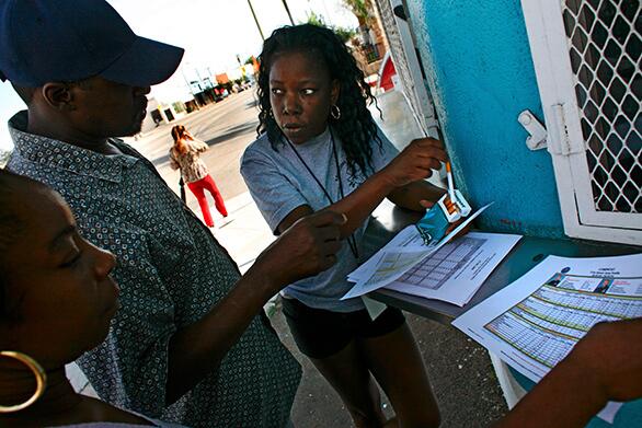 Robbie Warren, center, a founder of Advocates for Peace and Urban Unity, a community group that works to quell gang violence in a large area of South Los Angeles, looks over crime statistics with Tudy Flowers, left, and another resident who asked not to be identified.