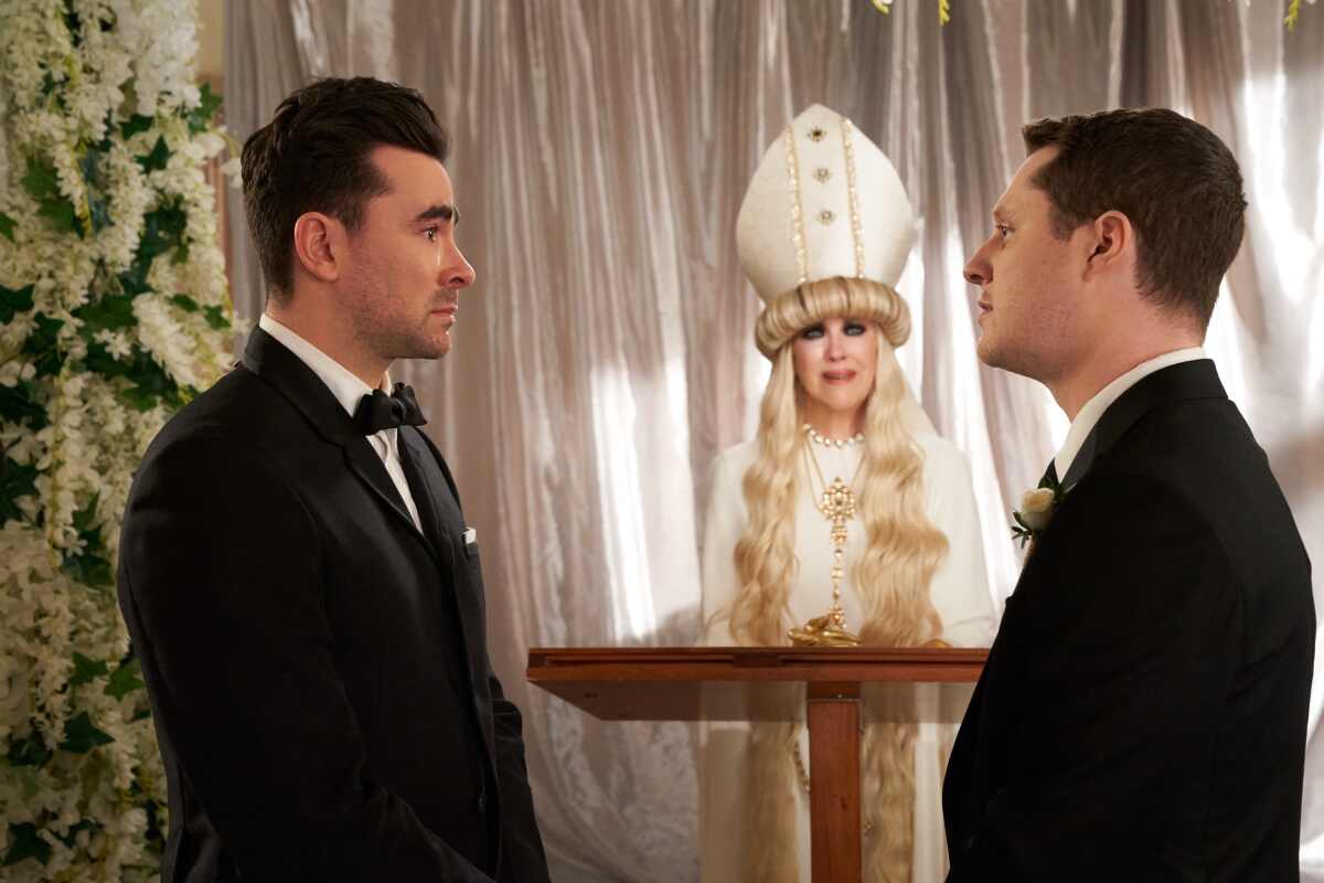 David (Dan Levy) and Patrick (Noah Reid) get married by Moira (Catherine O'Hara) in a scene from "Schitt's Creek."