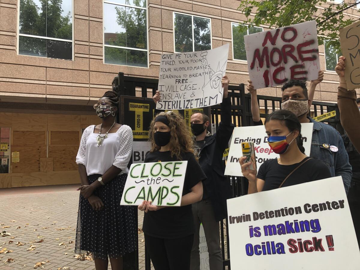 Dawn Wooten stands with protesters carrying signs outside a Georgia detention center.