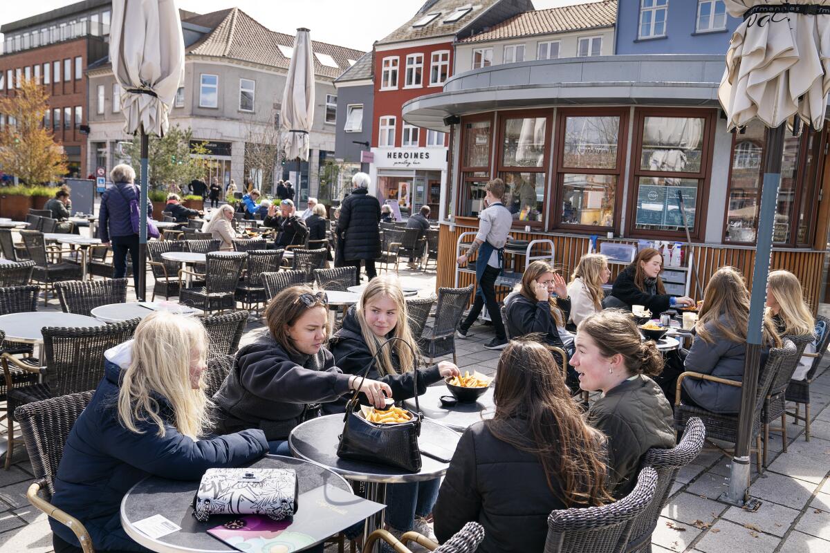 FILE - In this Wednesday April 21, 2021 file photo, people sit outside a restaurant for outdoor service in Roskilde Denmark, as cafes and bars reopened. After 548 days with restrictions to limit the spread of COVID-19, Denmark's high vaccination rate has enabled the Scandinavian country to become one of the first European Union nations to lift all domestic restrictions. The return to normality has been gradual, but as of Friday Sept. 10, 2021, the digital pass — a proof of having been vaccinated — is no longer required when entering night clubs, making it the last virus safeguard to fall. (Claus Bech/Ritzau Scanpix via AP, File)