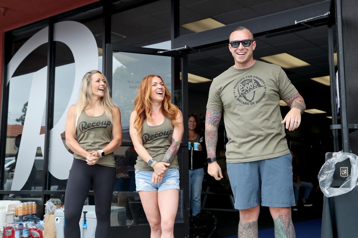 Co-owners Mattison Fetters, right, his wife Stevie, center, and Bo Wind at their Push-ups for Charity event.