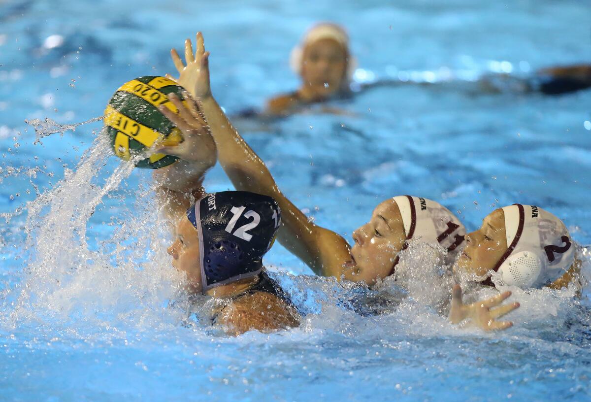 Newport Harbor’s Olivia Giolas (12) tries to get a shot off as Laguna Beach’s Emma Singer (11) and Morgan Van Alphen (2) close in during the semifinals of the CIF Southern Section Division 1 playoffs at Irvine’s Woollett Aquatics Center on Wednesday.
