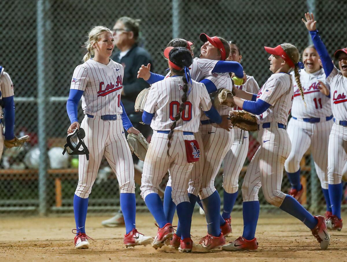 Los Alamitos pitcher Cari Ferguson (18), far left, is mobbed by her teammates after the final out against Huntington Beach.