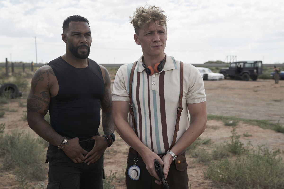Omari Hardwick and Matthias Schweighöfer stand pensively in the desert in the movie "Army of the Dead."