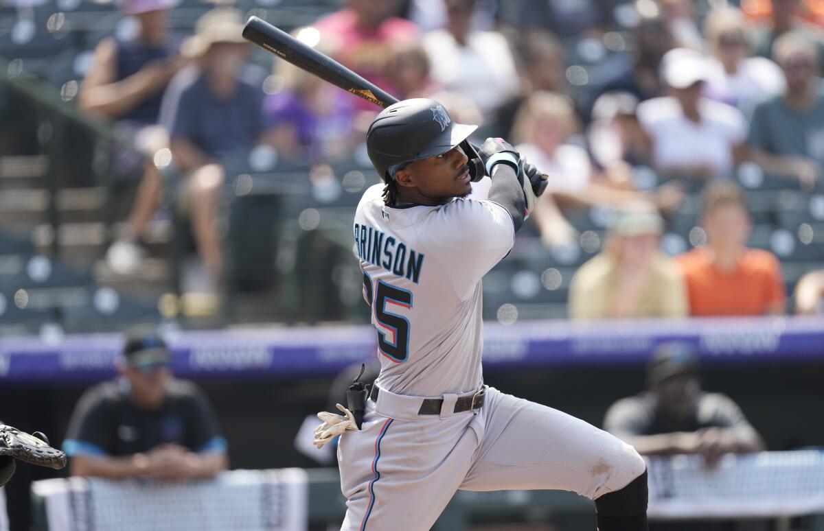 Miami Marlins' Lewis Brinson follows the flight of his double that drove in two runs off Colorado Rockies starting pitcher Kyle Freeland in the fifth inning of a baseball game Sunday, Aug. 8, 2021, in Denver. (AP Photo/David Zalubowski)