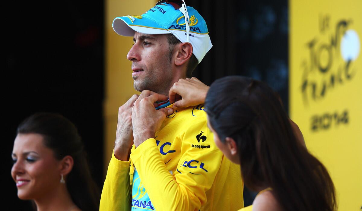 Vincenzo Nibali gets some help adjusting the collar of his yellow leader's jersey after the 12th stage of the Tou de France on Thursday in Saint-Etienne.
