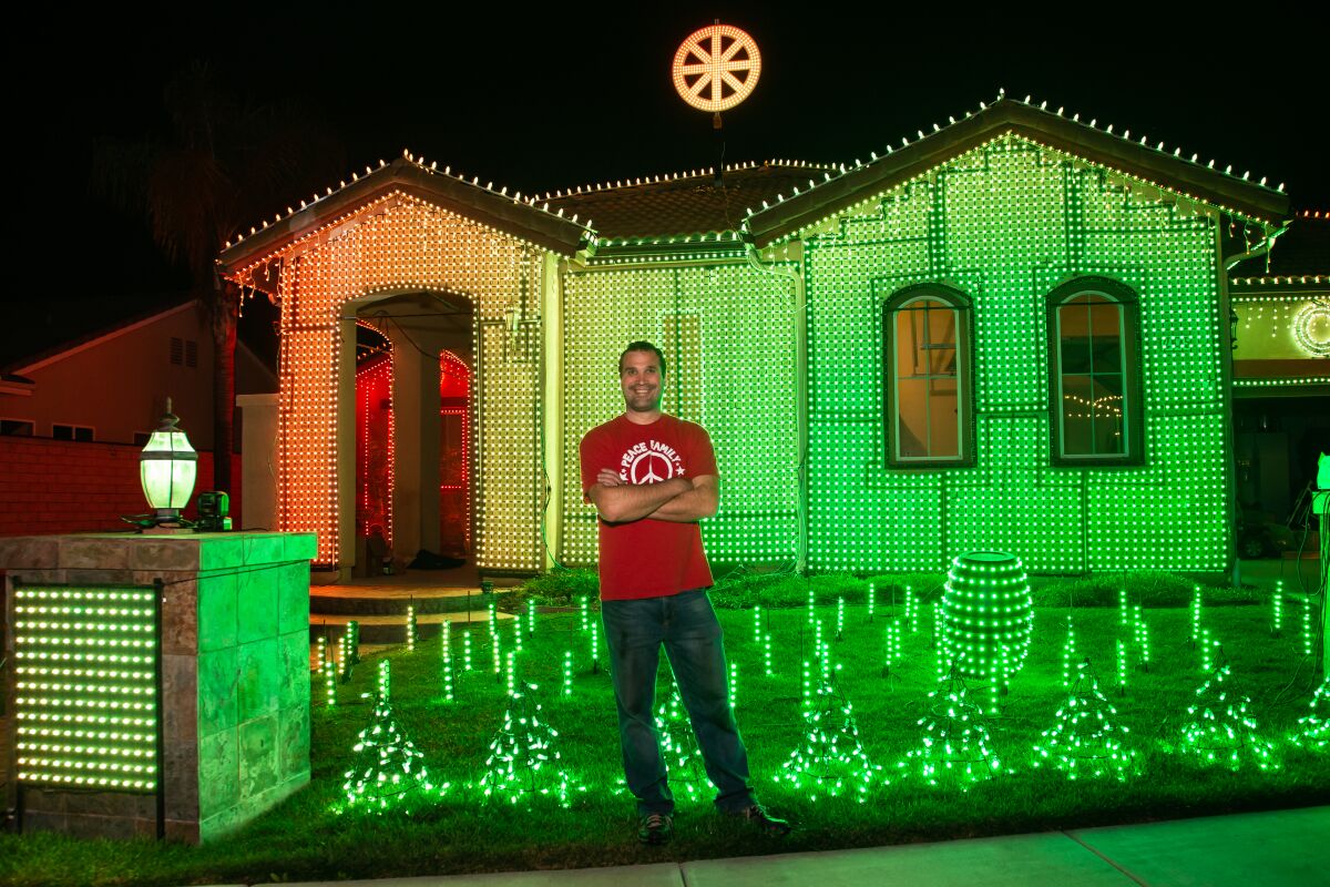 David Peace stands in front of his Escondido home, decked out with 35,000 pixel lights on which he produces a multimedia extravaganza that got him on national television last year.