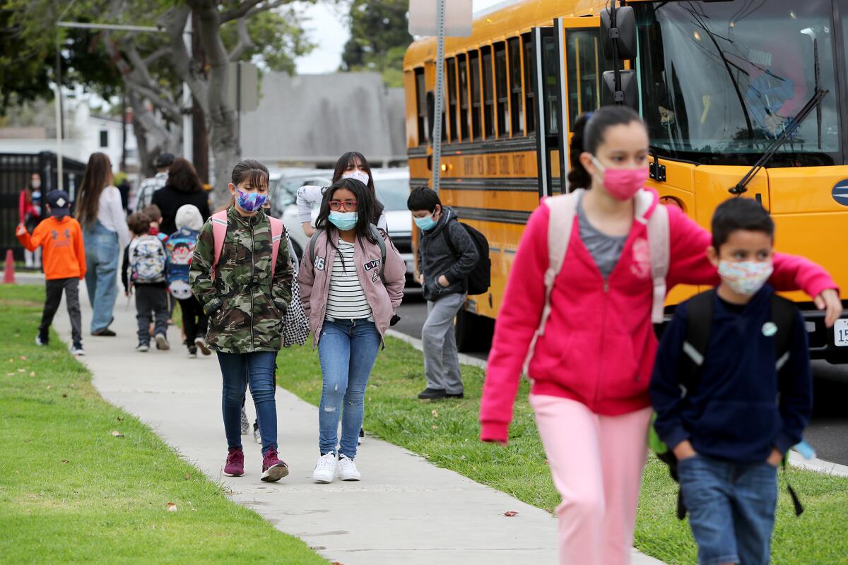 Students return to campus for their first full day of instruction at Adams Elementary School in Costa Mesa on Wednesday.