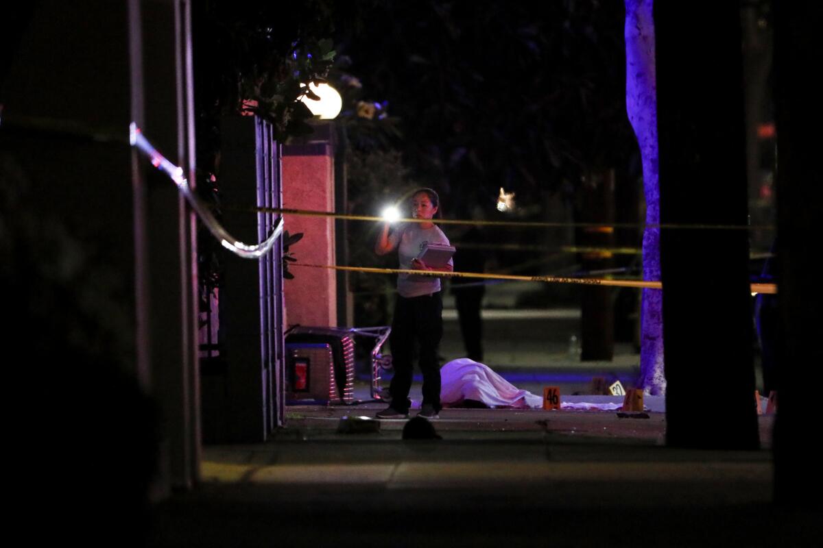 Investigators look over the body of a suspect 