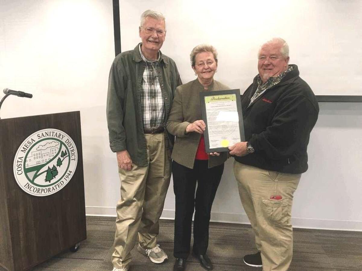 Art Goddard, left, and Mary Ellen Goddard, center, receive a proclamation.