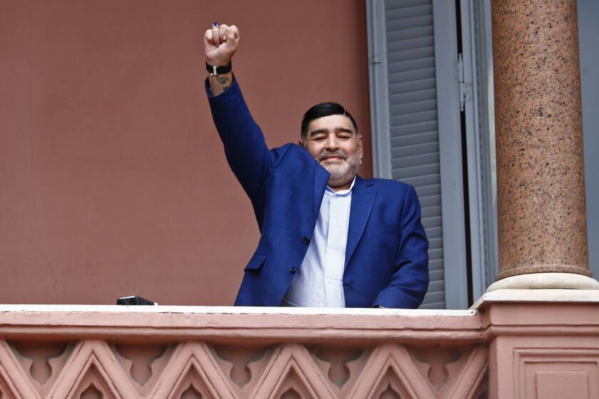 ARCHIVO - Diego Maradona saluda a la gente en la Casa Rosada, sede del gobierno de Argentina, tras una reunión con el presidente Alberto Fernández, el 26 de diciembre de 2019. (AP Foto/Marcos Brindicci)