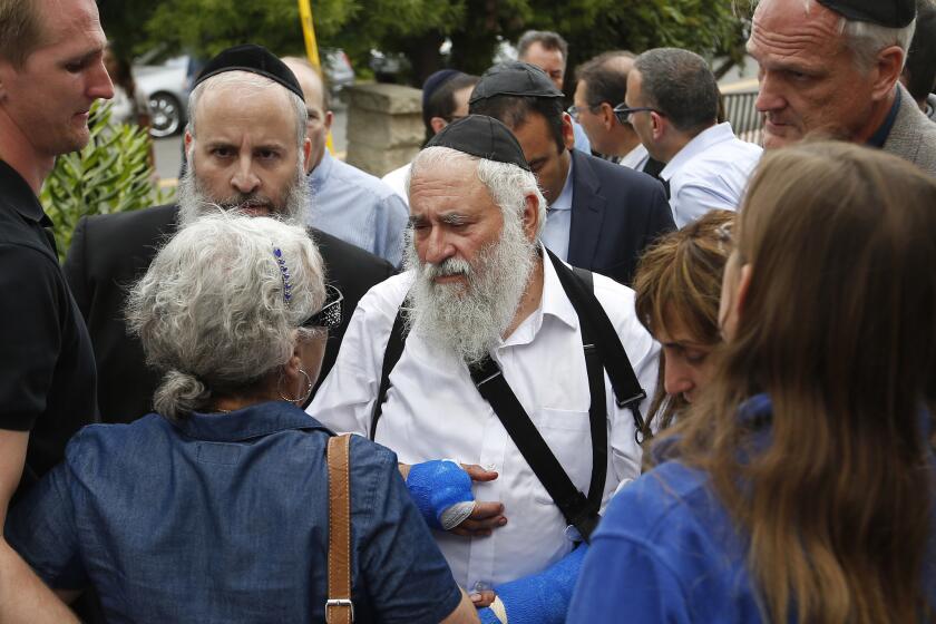Rabbi Yisroel Goldstein, center, meets with members of the congregation of Chabad of Poway the day after a deadly shooting took place there on April 28, 2019 in Poway, California. Goldstein was shot and lost a finger on his right hand.