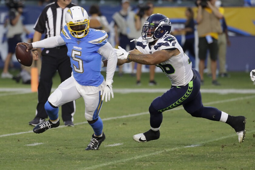 Chargers quarterback Tyrod Taylor, left, breaks away from Seattle Seahawks linebacker Mychal Kendricks.