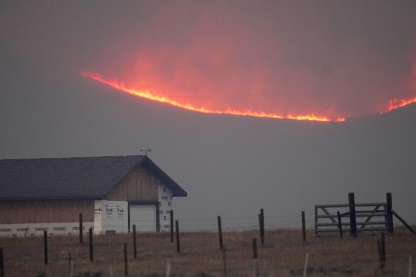 File—Flames rise from mountain ridges as a wildfire burns near a farmstead late Thursday, Oct. 22, 2020, near Granby, Colo. A bill is being introduced in the Colorado Legislature to create a $2-million pilot program to use cameras likely equipped with artificial intelligence technology in high-risk areas to help identify fires before they can burn out of control. (AP Photo/David Zalubowski, File)